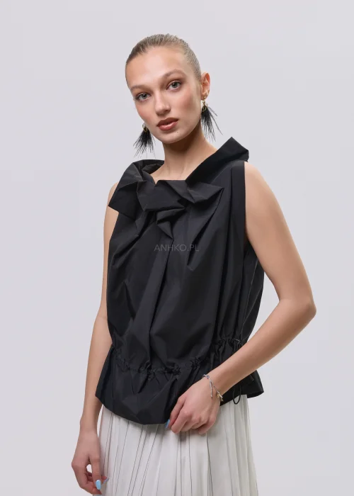Czarna bluzka damska bez rękawów z ozdobnym marszczeniem przy dekolcie i regulacją w talii, zestawiona z plisowaną spódnicą.