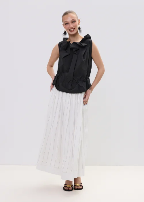 Czarna bluzka damska bez rękawów z ozdobnym marszczeniem przy dekolcie i regulacją w talii, zestawiona z plisowaną spódnicą.