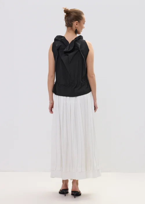 Czarna bluzka damska bez rękawów z ozdobnym marszczeniem przy dekolcie i regulacją w talii, zestawiona z plisowaną spódnicą.