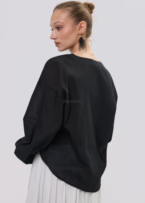 Czarna bluzka damska z kopertowym dekoltem i ozdobną falbaną, wykonana z lekkiego, półtransparentnego materiału o luźnym fasonie