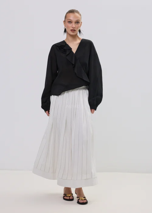 Czarna bluzka damska z kopertowym dekoltem i ozdobną falbaną, wykonana z lekkiego, półtransparentnego materiału o luźnym fasonie