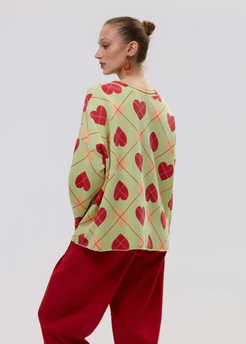 Luźna bluza damska oversize w kolorze limonkowym z czerwonym wzorem serc i geometryczną kratą, o szerokich rękawach i swobodnym fasonie.
