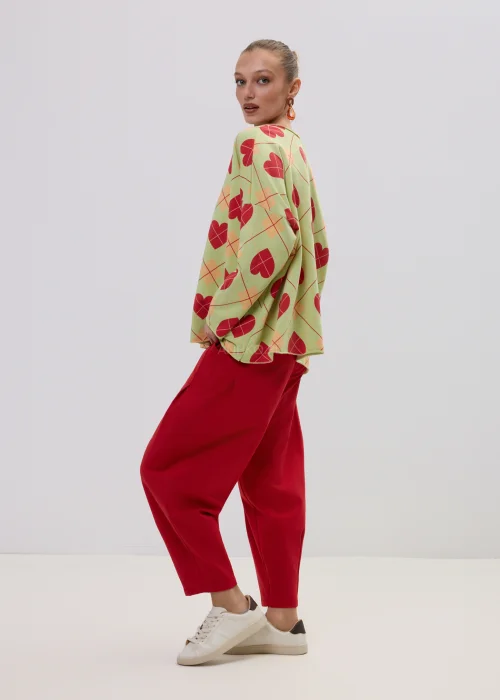 Luźna bluza damska oversize w kolorze limonkowym z czerwonym wzorem serc i geometryczną kratą, o szerokich rękawach i swobodnym fasonie.