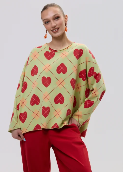 Luźna bluza damska oversize w kolorze limonkowym z czerwonym wzorem serc i geometryczną kratą, o szerokich rękawach i swobodnym fasonie.
