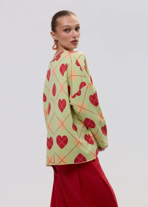 Luźna bluza damska oversize w kolorze limonkowym z czerwonym wzorem serc i geometryczną kratą, o szerokich rękawach i swobodnym fasonie.