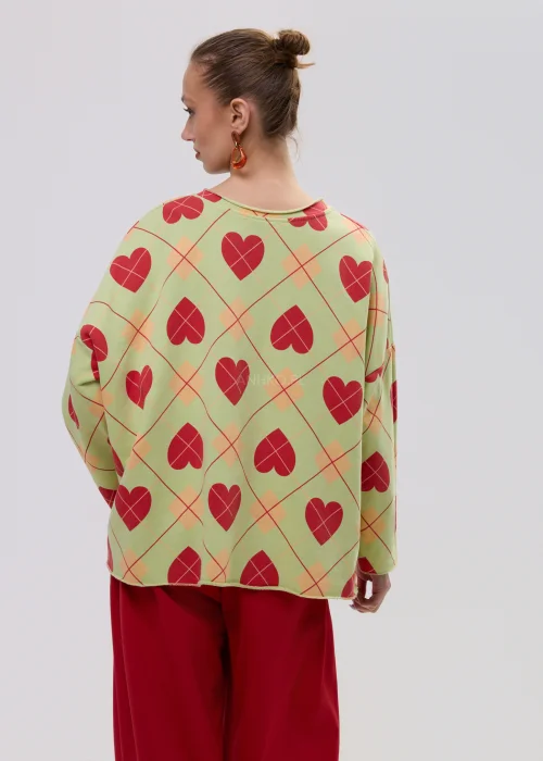 Luźna bluza damska oversize w kolorze limonkowym z czerwonym wzorem serc i geometryczną kratą, o szerokich rękawach i swobodnym fasonie.