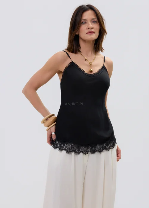 Czarna bluzka na ramiączkach z koronkowym wykończeniem przy dekolcie i dole, dopasowany fason, stylizacja z jasnymi spodniami.