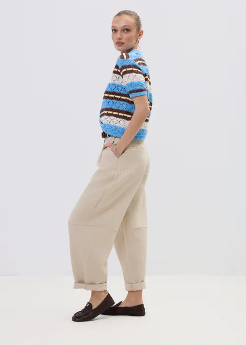 Ażurowy kardigan damski w paski w odcieniach błękitu i brązu z kołnierzykiem polo, stylizowany z beżowymi spodniami.