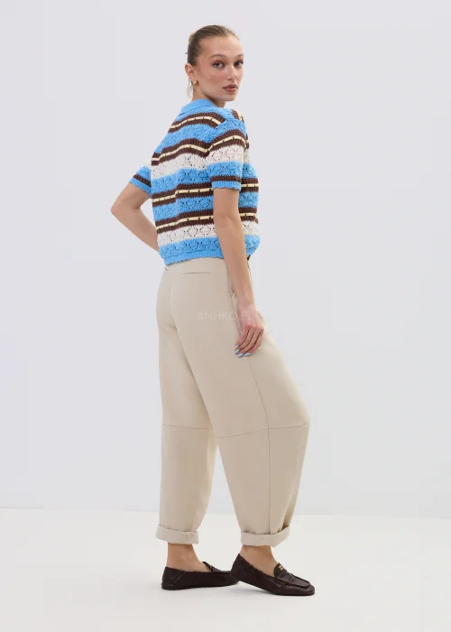 Ażurowy kardigan damski w paski w odcieniach błękitu i brązu z kołnierzykiem polo, stylizowany z beżowymi spodniami.