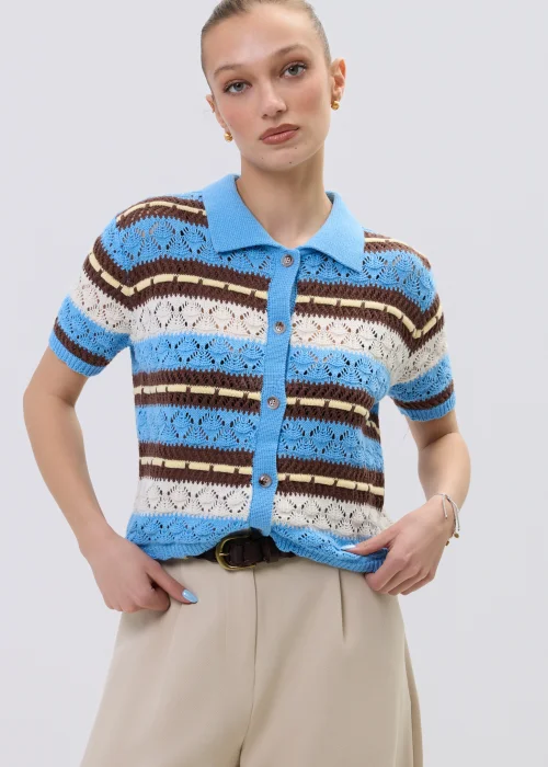 Ażurowy kardigan damski w paski w odcieniach błękitu i brązu z kołnierzykiem polo, stylizowany z beżowymi spodniami.