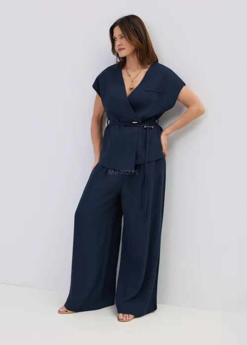 Granatowa kamizelka z dodatkiem lnu o kopertowym kroju, elegancki fason bez rękawów z paskiem w talii, stylizacja z szerokimi spodniami.