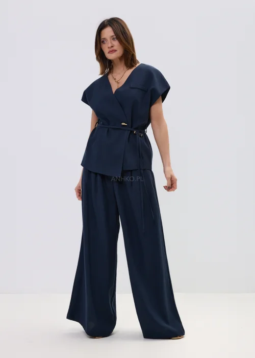 Granatowa kamizelka z dodatkiem lnu o kopertowym kroju, elegancki fason bez rękawów z paskiem w talii, stylizacja z szerokimi spodniami.