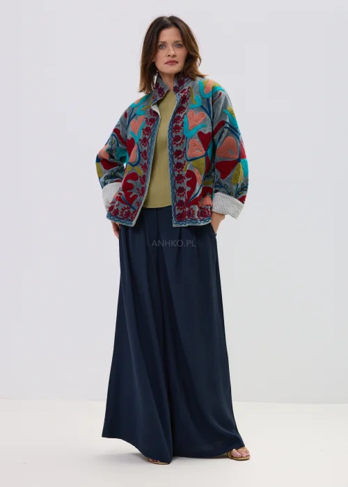 Welurowy żakiet w kolorze szaro-niebieskim z bogatym haftem w kwiaty i serca, oversize’owy fason, stylizacja casual z szerokimi spodniami.