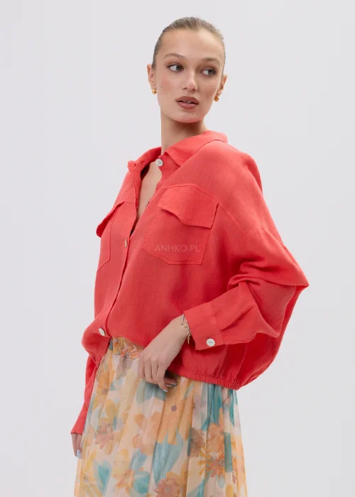 Koralowa koszula lniana damska oversize z kieszeniami i guzikami, lekka tkanina, stylizacja z pastelową spódnicą w kwiatowy wzór.