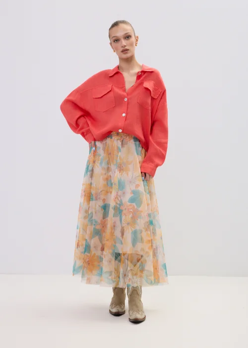 Koralowa koszula lniana damska oversize z kieszeniami i guzikami, lekka tkanina, stylizacja z pastelową spódnicą w kwiatowy wzór.