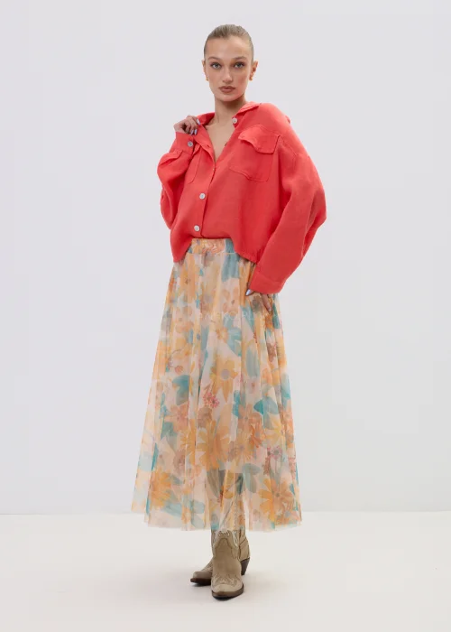 Koralowa koszula lniana damska oversize z kieszeniami i guzikami, lekka tkanina, stylizacja z pastelową spódnicą w kwiatowy wzór.