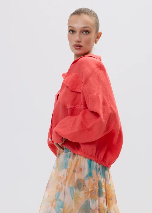 Koralowa koszula lniana damska oversize z kieszeniami i guzikami, lekka tkanina, stylizacja z pastelową spódnicą w kwiatowy wzór.