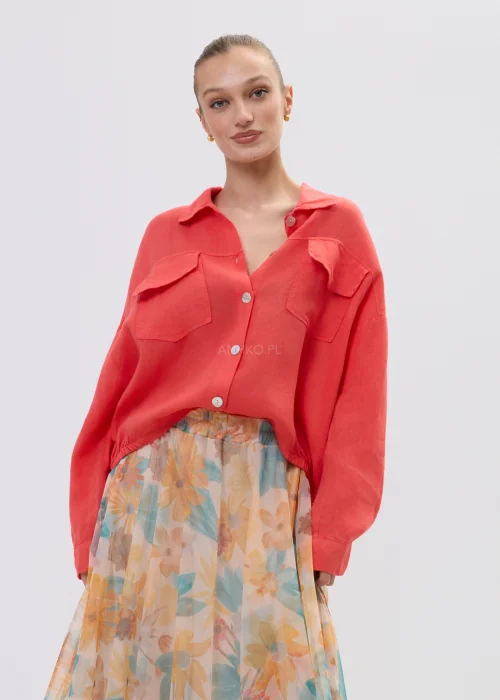 Koralowa koszula lniana damska oversize z kieszeniami i guzikami, lekka tkanina, stylizacja z pastelową spódnicą w kwiatowy wzór.