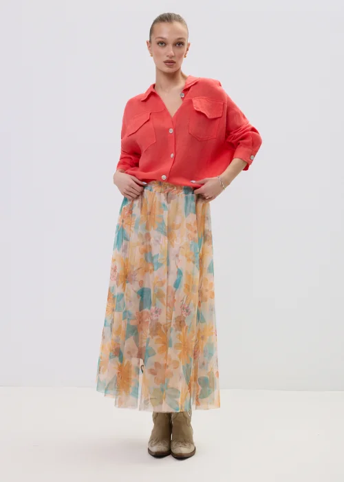 Koralowa koszula lniana damska oversize z kieszeniami i guzikami, lekka tkanina, stylizacja z pastelową spódnicą w kwiatowy wzór.