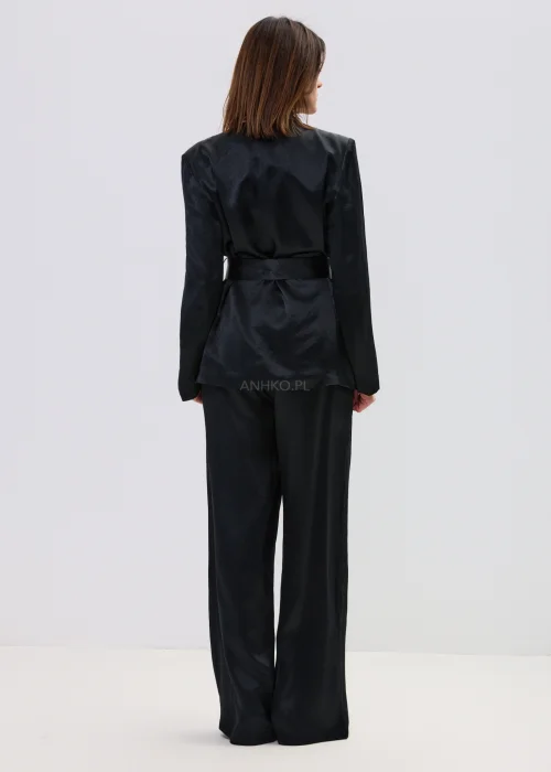 Czarny garnitur satynowy damski z wiązaną marynarką i szerokimi spodniami, elegancki zestaw o płynnej strukturze materiału.