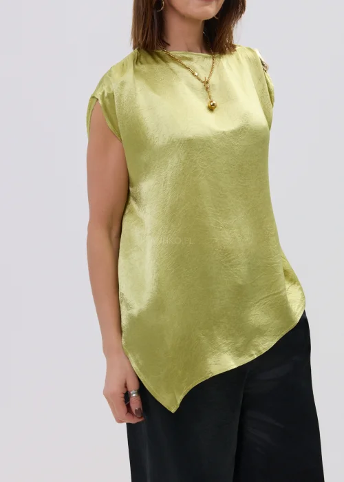 Limonkowa bluzka satynowa o luźnym fasonie z krótkim rękawem i ozdobnym pierścieniem na ramieniu, zestawiona z czarnymi spodniami, elegancka stylizacja.