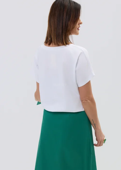 Biała koszulka z krótkim rękawem z nadrukiem cytryn i liści w stylu ilustracyjnym, zestawiona z zieloną spódnicą kopertową.