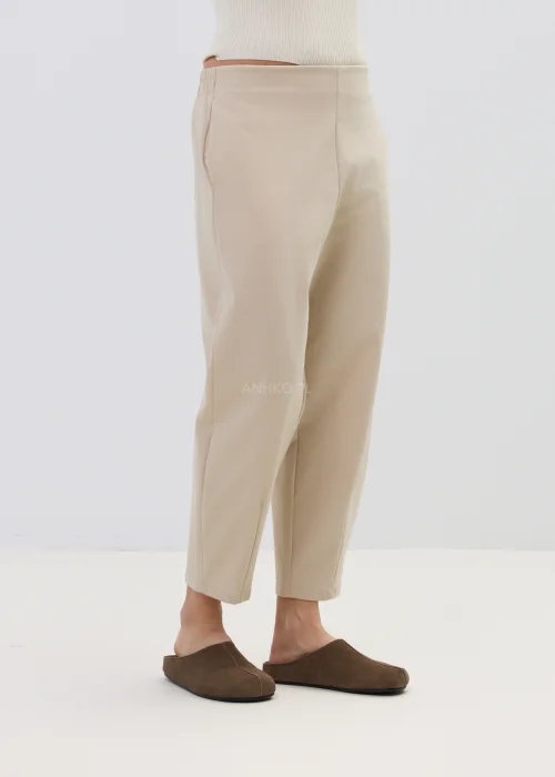 Beżowe spodnie damskie o prostym, lekko zwężanym kroju z wysokim stanem, minimalistyczny fason w elegancko-casualowej stylizacji.