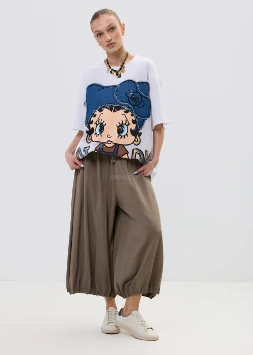 Biała bluzka oversize z dużą aplikacją dziewczynki w stylu cartoon z jeansową kokardą i zdobieniami, stylizowana ze spódnicą w casualowym looku.