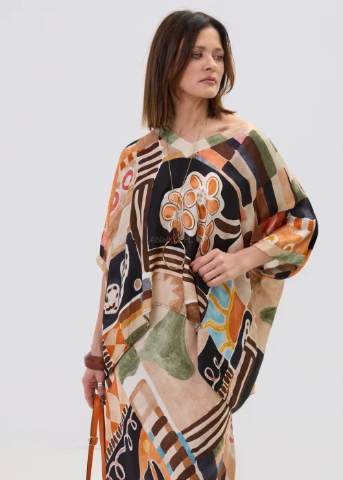 Wzorzysta bluzka oversize w geometryczny print w odcieniach beżu, czerni i pomarańczu, z luźnym rękawem, stylizowana w komplecie ze spódnicą w artystycznym looku.