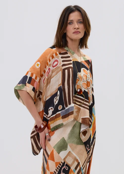Wzorzysta bluzka oversize w geometryczny print w odcieniach beżu, czerni i pomarańczu, z luźnym rękawem, stylizowana w komplecie ze spódnicą w artystycznym looku.