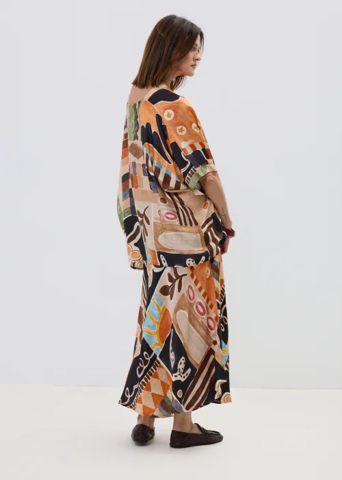 Wzorzysta bluzka oversize w geometryczny print w odcieniach beżu, czerni i pomarańczu, z luźnym rękawem, stylizowana w komplecie ze spódnicą w artystycznym looku.