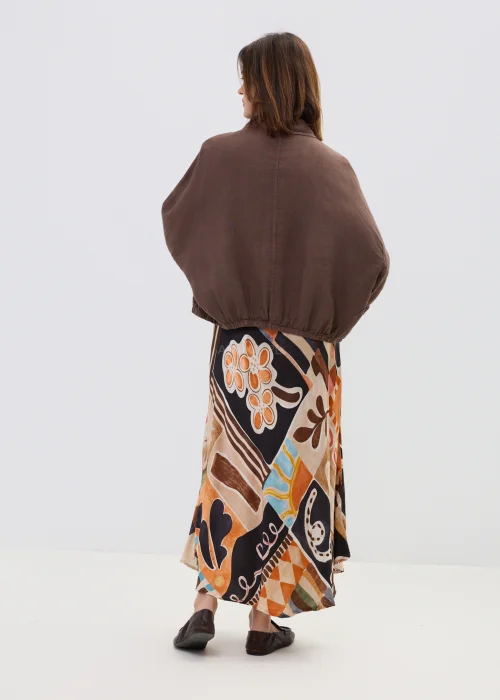 Brązowa lniana koszula oversize z kieszeniami na piersi i guzikami, lekka i naturalna, stylizowana z wzorzystą spódnicą w casualowym looku.