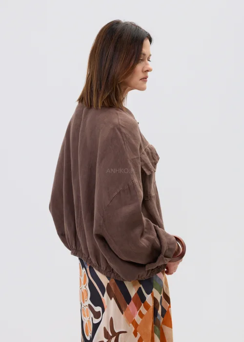 Brązowa lniana koszula oversize z kieszeniami na piersi i guzikami, lekka i naturalna, stylizowana z wzorzystą spódnicą w casualowym looku.