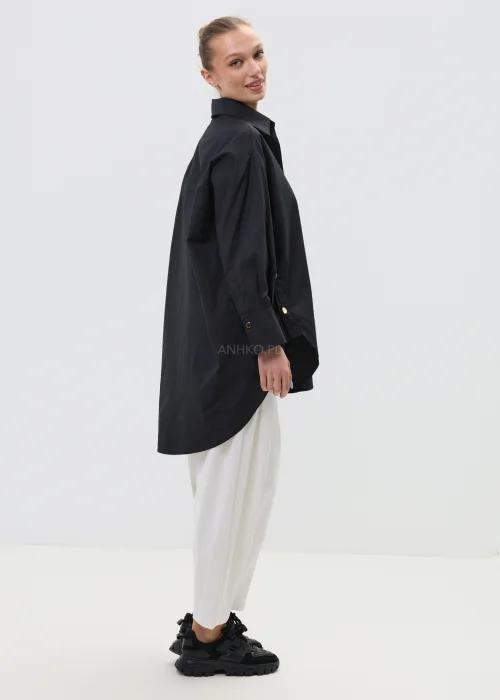 Czarna koszula damska oversize z klasycznym kołnierzem i zapięciem na guziki, minimalistyczny fason z kieszenią na piersi w elegancko-casualowej stylizacji.