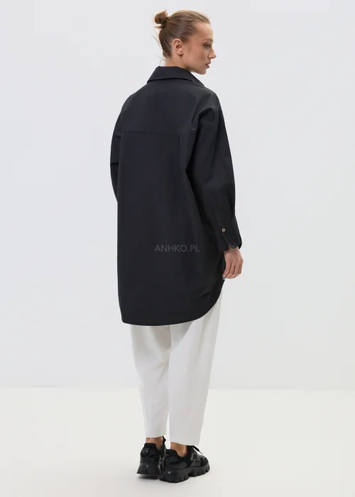 Czarna koszula damska oversize z klasycznym kołnierzem i zapięciem na guziki, minimalistyczny fason z kieszenią na piersi w elegancko-casualowej stylizacji.
