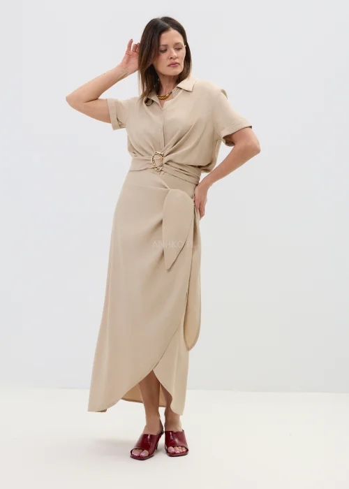 Beżowa spódnica z kopertowym wiązaniem w talii, o płynnie układającym się fasonie, elegancka i minimalistyczna w stylizacji z sandałami na obcasie.
