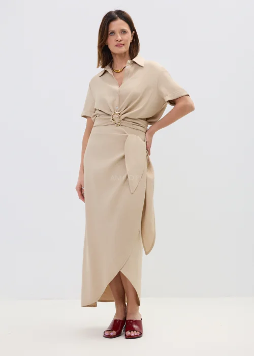 Beżowa bluzka damska z krótkim rękawem i ozdobnym wiązaniem z klamrą, lekka i elegancka.