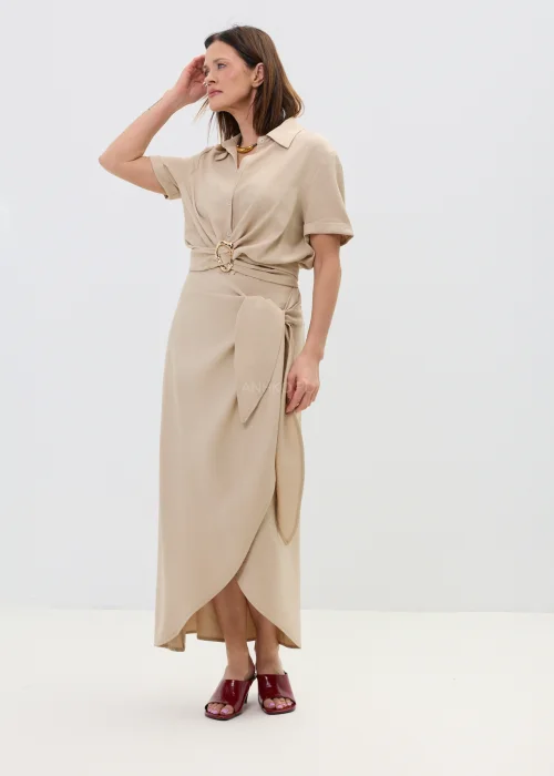 Beżowa bluzka damska z krótkim rękawem i ozdobnym wiązaniem z klamrą, lekka i elegancka.