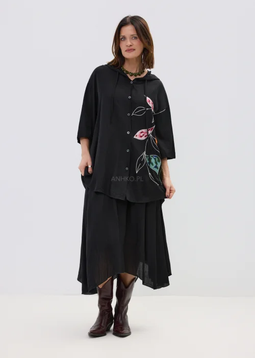 Czarna spódnica midi o zwiewnym kroju z asymetrycznym dołem, stylizowana z wysokimi botkami w eleganckim wydaniu.