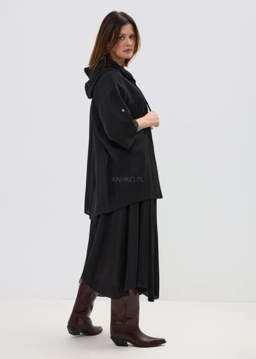 Czarna spódnica midi o zwiewnym kroju z asymetrycznym dołem, stylizowana z wysokimi botkami w eleganckim wydaniu.