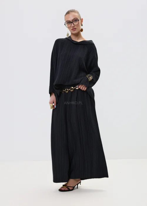 Czarna bluzka damska w delikatny prążek z luźnym krojem i szerokim dekoltem typu komin, w eleganckiej stylizacji z biżuterią.