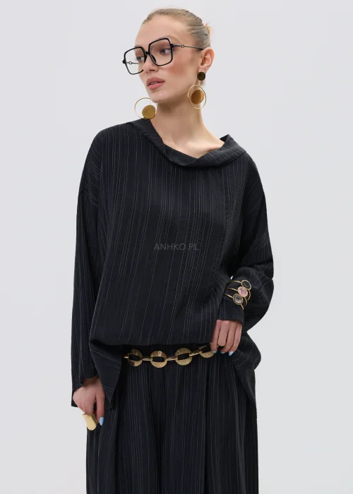 Czarna bluzka damska w delikatny prążek z luźnym krojem i szerokim dekoltem typu komin, w eleganckiej stylizacji z biżuterią.