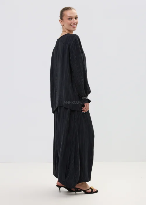 Czarna bluzka damska w delikatne pionowe prążki, o luźnym kroju z długim rękawem i szerokim dekoltem.