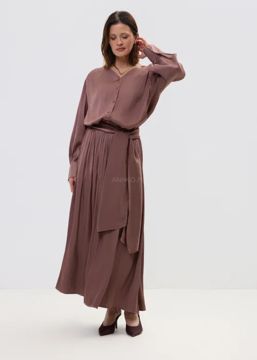 Komplet damski w kolorze ciepłego brązu, składający się z bluzki z długim rękawem i spódnicy maxi, o lejącym materiale i eleganckim, swobodnym kroju.