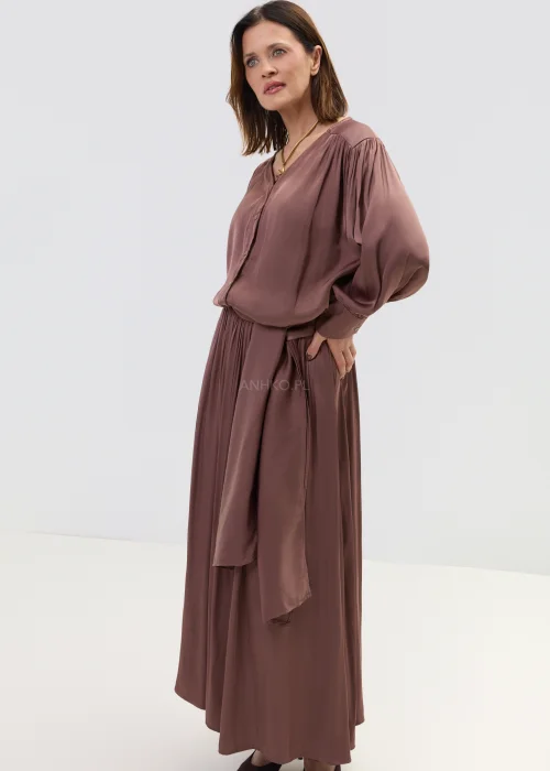 Komplet damski w kolorze ciepłego brązu, składający się z bluzki z długim rękawem i spódnicy maxi, o lejącym materiale i eleganckim, swobodnym kroju.