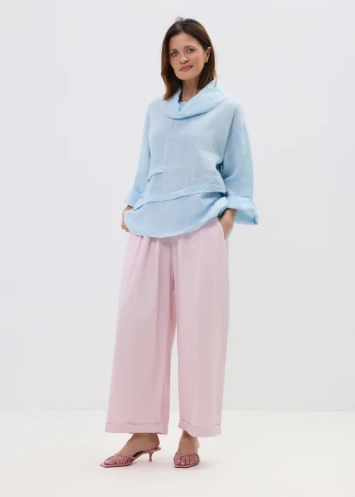 Różowe spodnie damskie z szerokimi nogawkami i podwiniętym dołem, luźny fason, elegancko-casualowa stylizacja.