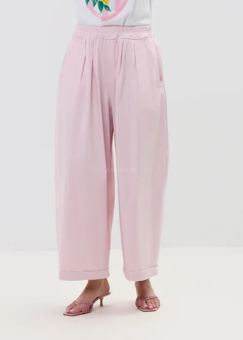 Różowe spodnie damskie z szerokimi nogawkami i podwiniętym dołem, luźny fason, elegancko-casualowa stylizacja.