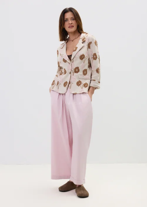 Różowe spodnie damskie z szerokimi nogawkami i podwiniętym dołem, luźny fason, elegancko-casualowa stylizacja.