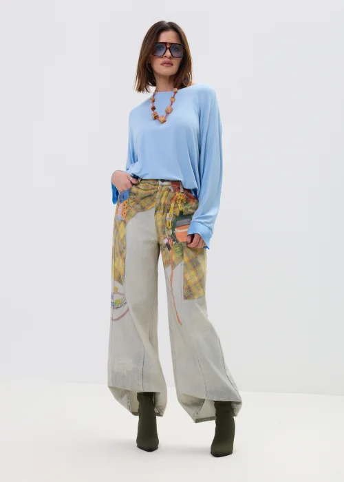 Niebieska bluzka damska o luźnym kroju z długim rękawem i szerokim dekoltem, lekki materiał, casualowa stylizacja.