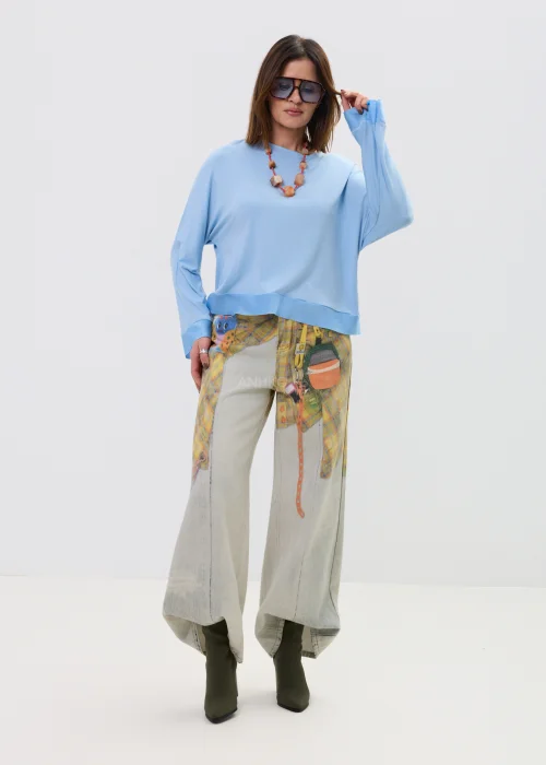 Niebieska bluzka damska o luźnym kroju z długim rękawem i szerokim dekoltem, lekki materiał, casualowa stylizacja.